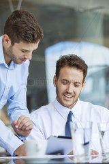 Businessman showing proposal to colleague on digital tablet