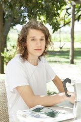 Young man at breakfast table outdoors