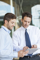 Businessmen collaborating using digital tablet