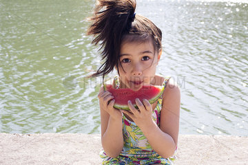 Girl eating watermelon outdoors