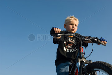 Freiburg im Breisgau  8-jaehriger Junge sitzt auf seinem Mountainbike