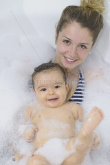 Mother and baby taking a bubble bath together