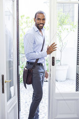 Man standing in open doorway  smiling  portrait