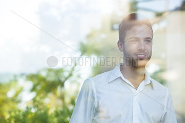 Businessman looking out of window from office