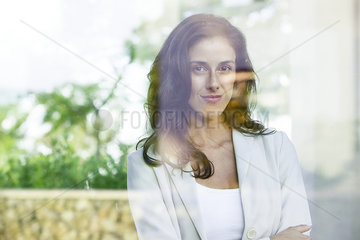 Businesswoman looking out of window from office