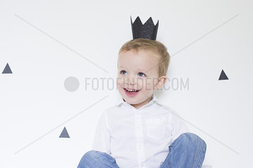 Little boy wearing paper crown