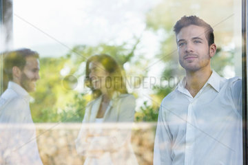 Businessman looking out window lost in thought