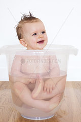 Baby bathing in a plastic tub
