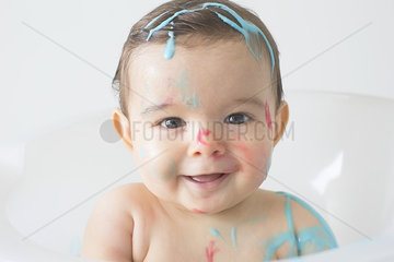 Baby splattered in colorful soap at bathtime
