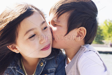 Little boy kissing his sister's cheek