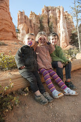 Children sitting on tree trunk at Bryce Canyon National Park  Utah  USA