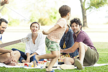 Family enjoying picnic in park  boy running around