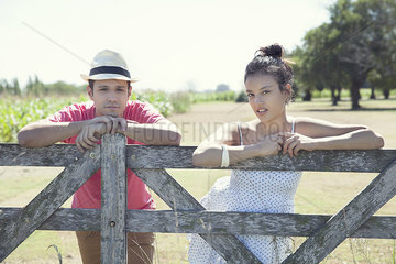 Couple learning against wooden fence  portrait