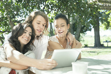 Young friends watching video on digital tablet together