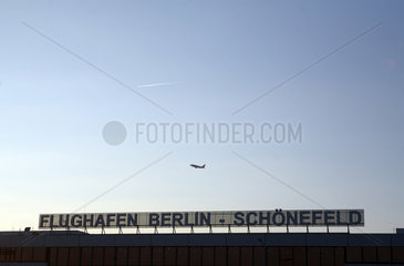 Schoenefeld  Brandenburg  Startendes Flugzeug ueber dem Gebaeude des Flughafens Schoenefeld