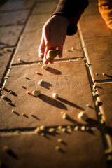 Sevilla  Spanien  ein Kind wirft kleine Steine auf den Boden