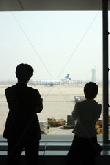 Zwei Personen schauen auf den Flughafen von Peking