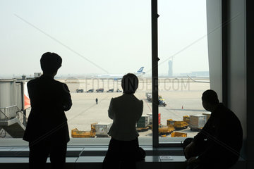 Drei Personen schauen auf den Flughafen von Peking
