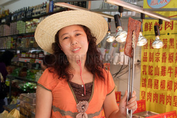 Macau  China  Frau verkauft gebratenes Fleisch