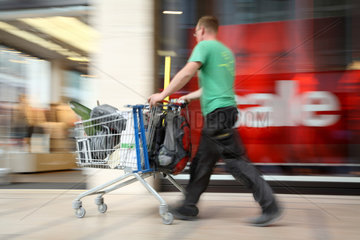 Berlin  Deutschland  ein Mann schiebt einen vollen Einkaufswagen vor sich her