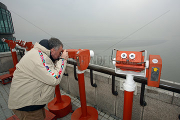Odusan  Mann schaut durch ein Fernsichtgeraet auf einer Aussichtsplattform des Odusan Unification Observatory