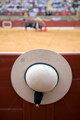 Ein castoreno (runder Hut des Pikadors) haengt bei einem Stierkampf an der Bande  Spanien