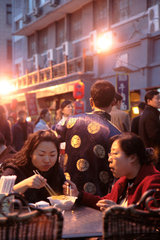 Peking  zwei Chinesinnen essen in einem Strassenlokal