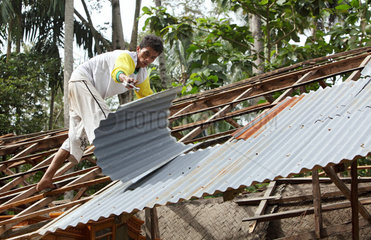 Kampuang Bukik catiak Tawang  Indonesien  ein Mann deckt das Dach seines Hauses ab