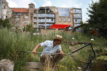 Berlin  Deutschland  Mann schaut nach Froeschen in seinem von ihm angelegten Teich