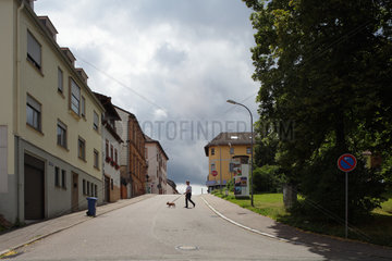 Pirmasens  Deutschland  Mann mit Hund ueberquert eine leere Strasse