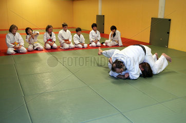 Berlin  Deutschland  Kinder in einem Judokurs. Judolehrer zeigt eine Wurftechnik