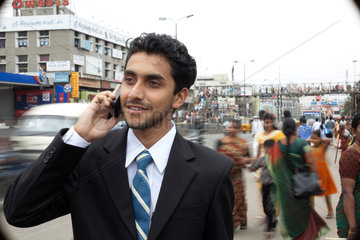 Coimbatore  Indien  junger indischer Geschaeftsmann mit Mobiltelefon