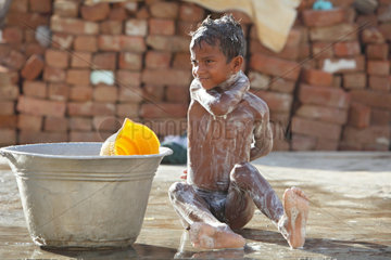 Kokilamedu  Indien  ein Kind waescht sich auf der Strasse