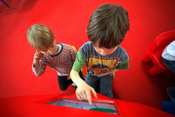 Geschwister spielen an einem Bildschirm  Kinderland Rostock