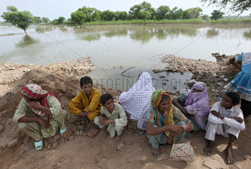 Muzaffargarh  Pakistan  Kinder sitzen am Rande ueberfluteter Felder