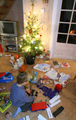 Wendisch Rietz  Deutschland  Junge spielt am Heiligenabend mit seinen Geschenken