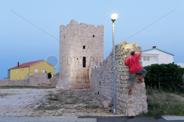 Rezanci  Kroatien  ein Mann klettert auf die alte Stadtmauer von Rezanci
