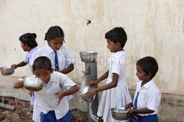 Navatkerny  Sri Lanka  Schueler holen sich sauberes Trinkwasser an einer Wasserpumpe