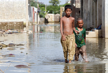 Nowshera  Pakistan  Kinder laufen durch eine ueberschwemmte Strasse