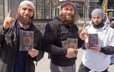 Berlin  Deutschland  Maenner zeigen mit erhobenem Zeigefinger den Koran