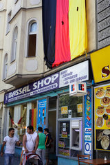 Berlin  Deutschland  riesige Deutschlandfahne ueber dem Bassal Shop in der Sonnenallee
