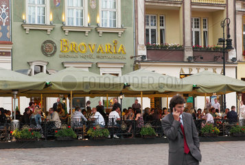 Posen  Polen  junger Mann telefoniert mit Handy vor dem bekannten Hotel Brovaria