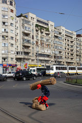 Bukarest  Rumaenien  schwer bepackter Mann ueberquert eine Strasse im Zentrum in Bukarest