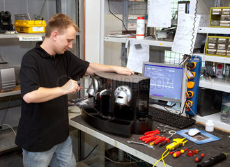 Duisburg  Deutschland  Fachkraft fuer Automatenservice repariert eine Kaffeestation