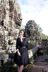 Angkor Wat  Kambodscha  eine junge Asiatin telefoniert mit ihrem Handy in der Anlage Bayon