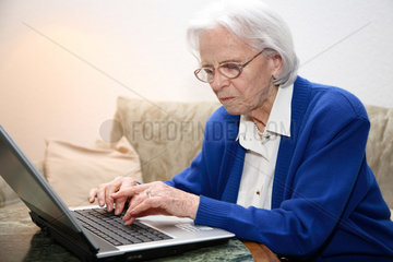 Berlin  Deutschland  eine alte Frau schreibt am Laptop