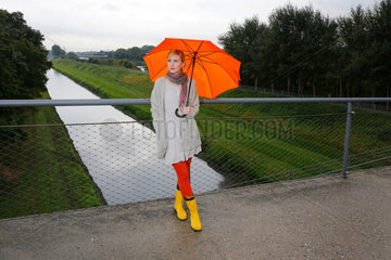 Oberhausen  Deutschland  eine junge Frau geht bei Regenwetter mit Regenschirm spazieren