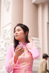 Ho-Chi-Minh-Stadt  Vietnam  Frau in traditionellem Kleid vor der Alten Oper