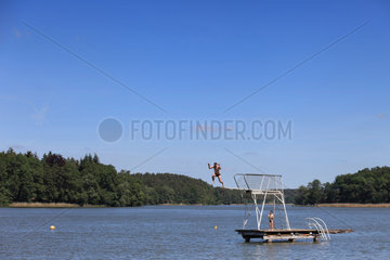 Templin  Deutschland  Mann springt von einem Sprungbrett in einen See