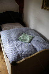 Mechow  Deutschland  ein einfaches Bett in einem Schlafzimmer eines Bauernhauses